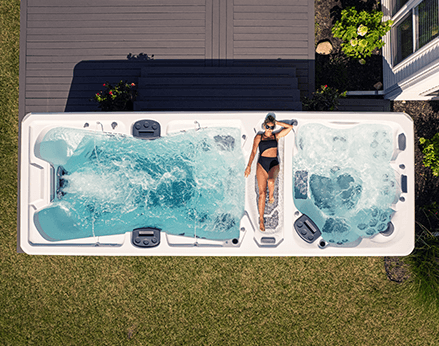 Woman lounging on a swim spa sun deck.