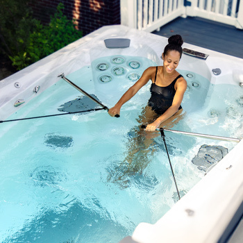 Woman working out in a swim spa with the H2Xercise Fitness System.